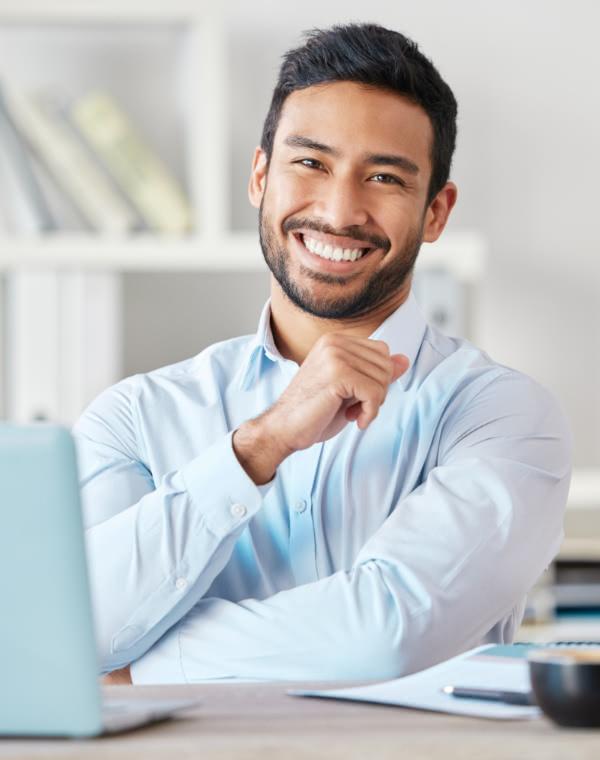 Man in suit smiling with hands in the air