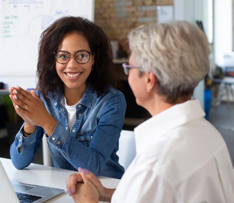 Young professional woman meeting with older professional woman